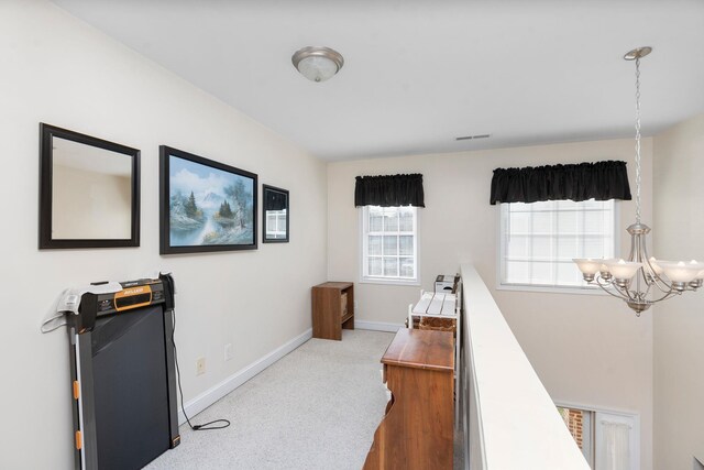 home office with an inviting chandelier and light carpet