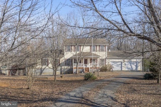 colonial inspired home with a garage and covered porch