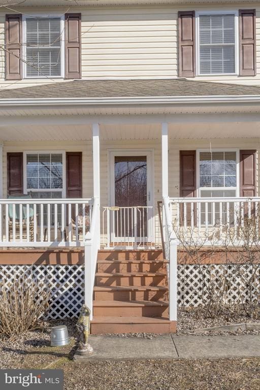 view of exterior entry featuring covered porch