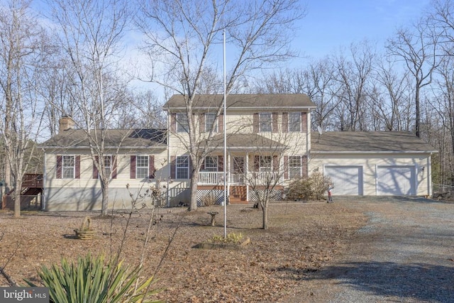 colonial inspired home featuring a garage and a porch