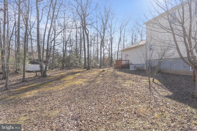 view of yard with a wooden deck and central AC