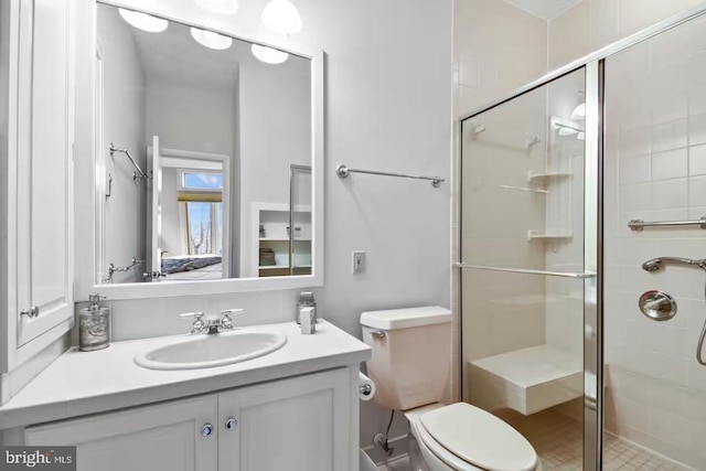 full bathroom featuring vanity, a shower stall, toilet, and ensuite bathroom