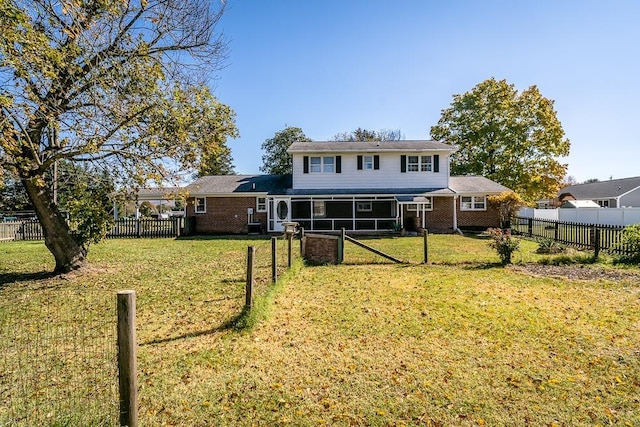 back of house featuring a lawn and a sunroom