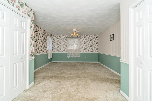 carpeted empty room with a textured ceiling