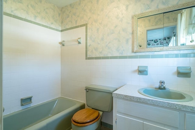 bathroom featuring vanity, tile walls, and toilet