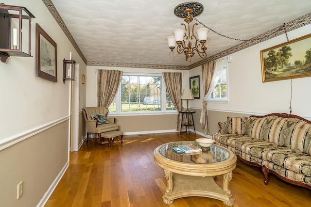 living room with an inviting chandelier, a wealth of natural light, ornamental molding, and dark hardwood / wood-style floors