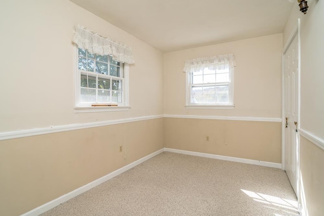 empty room with a healthy amount of sunlight and carpet flooring