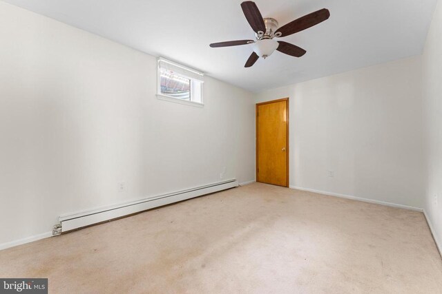 empty room featuring baseboard heating, light colored carpet, and ceiling fan