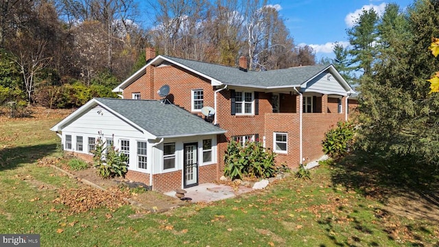 rear view of property with a lawn