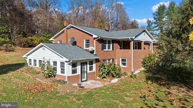 rear view of property with a lawn
