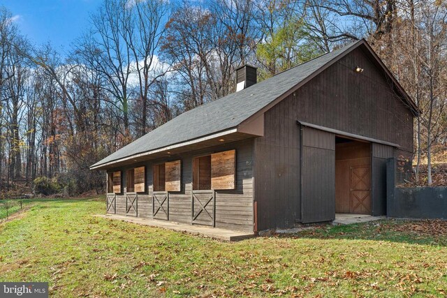 exterior space with an outdoor structure and a lawn