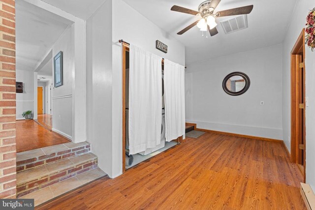 hall featuring baseboard heating and light hardwood / wood-style floors