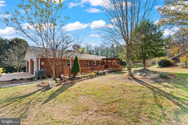 view of yard featuring a garage, central AC, and a deck