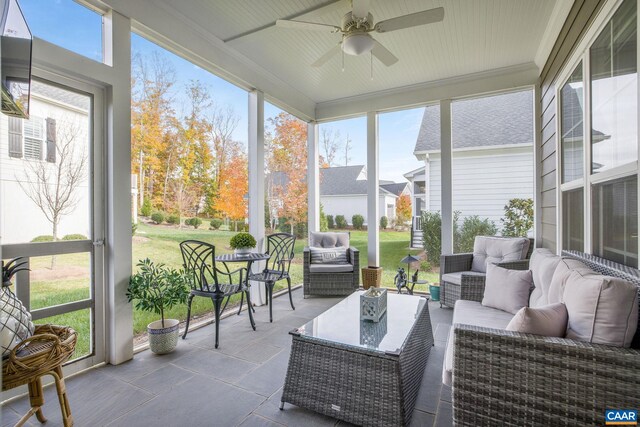 sunroom / solarium featuring a ceiling fan