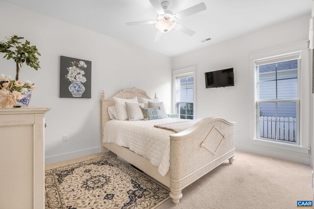 bedroom featuring light carpet, baseboards, visible vents, and ceiling fan