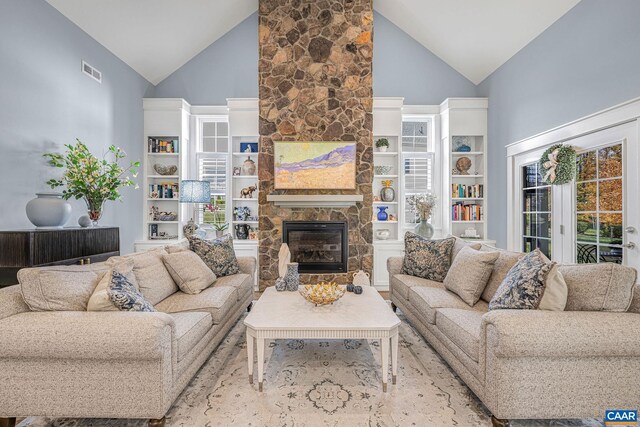 living room with high vaulted ceiling, a fireplace, and visible vents