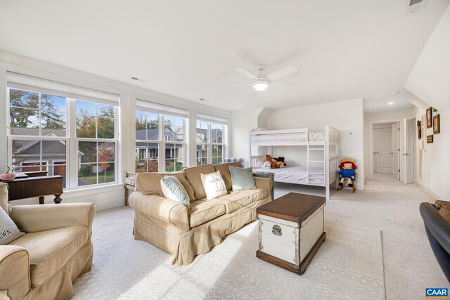 living room with ceiling fan, baseboards, and light colored carpet