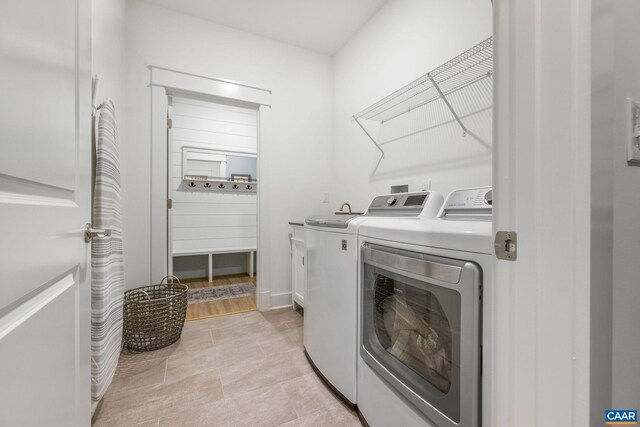 washroom featuring light tile patterned floors, separate washer and dryer, and cabinet space