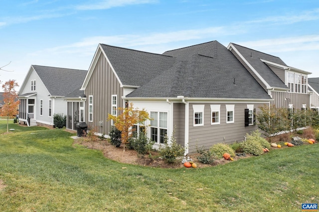 view of property exterior featuring roof with shingles, board and batten siding, and a yard