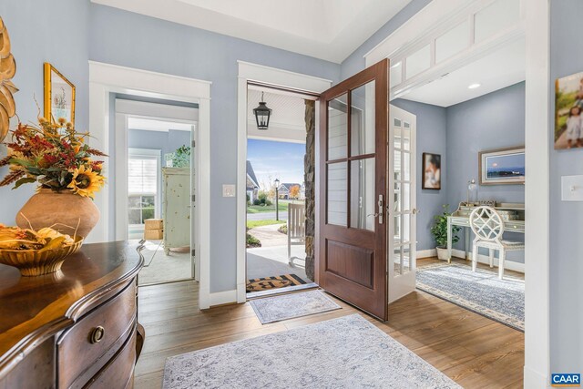 foyer entrance with wood finished floors and baseboards