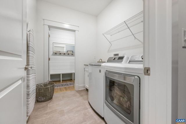 washroom with washing machine and dryer, cabinet space, and light tile patterned floors