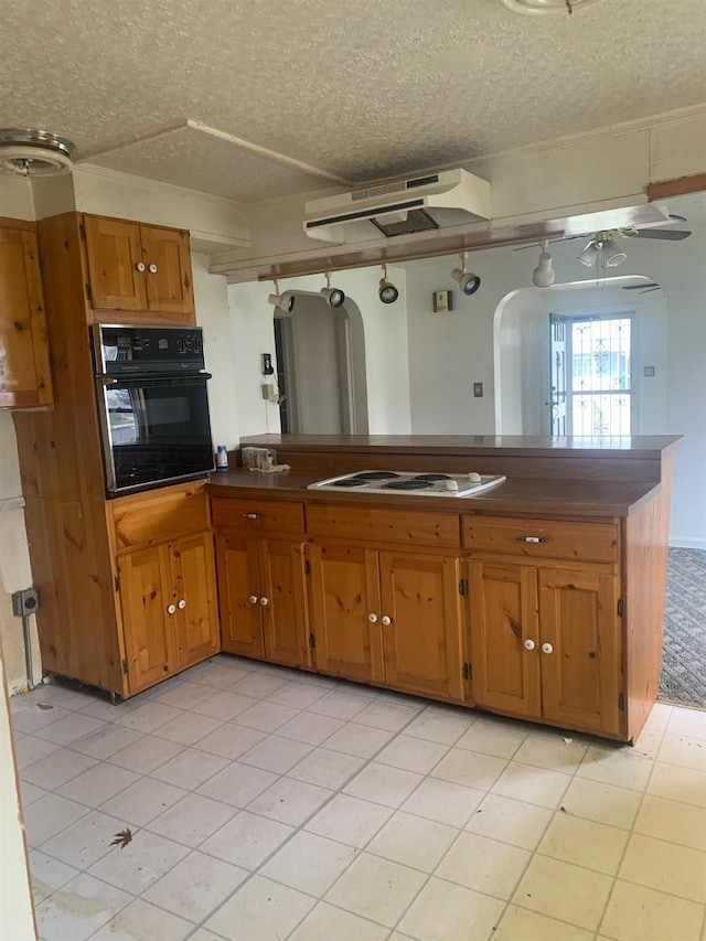 kitchen with oven, a textured ceiling, kitchen peninsula, and white electric stovetop