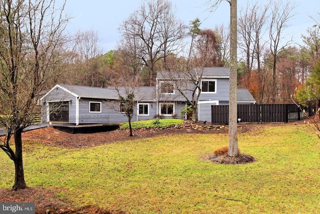 view of front of property with fence, a shingled roof, and a front yard