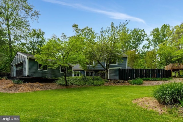 view of front of property with fence, a shingled roof, and a front yard