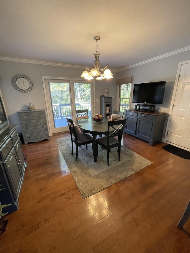 dining area featuring crown molding, dark hardwood / wood-style flooring, and an inviting chandelier