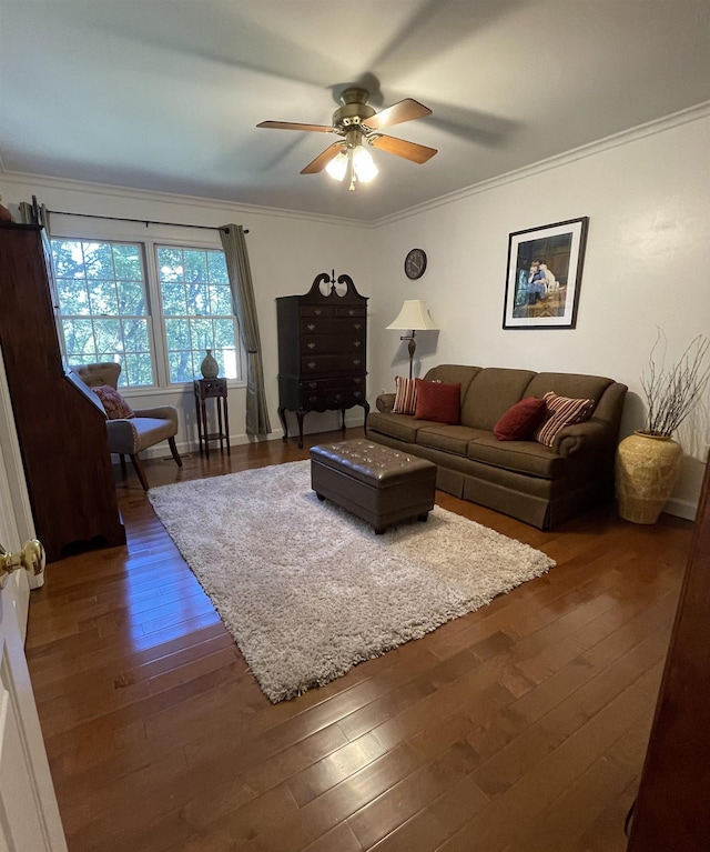 living room featuring dark wood-type flooring, ceiling fan, and ornamental molding