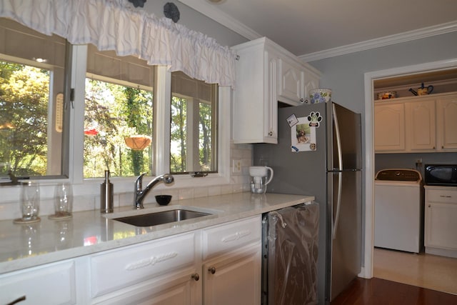 kitchen featuring white cabinetry, sink, ornamental molding, and a healthy amount of sunlight