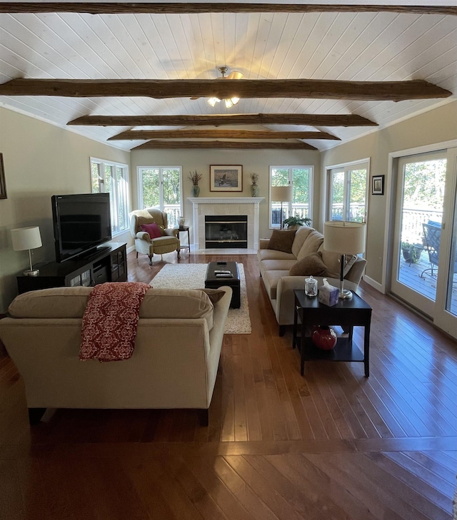 living room featuring beamed ceiling, plenty of natural light, and dark hardwood / wood-style floors