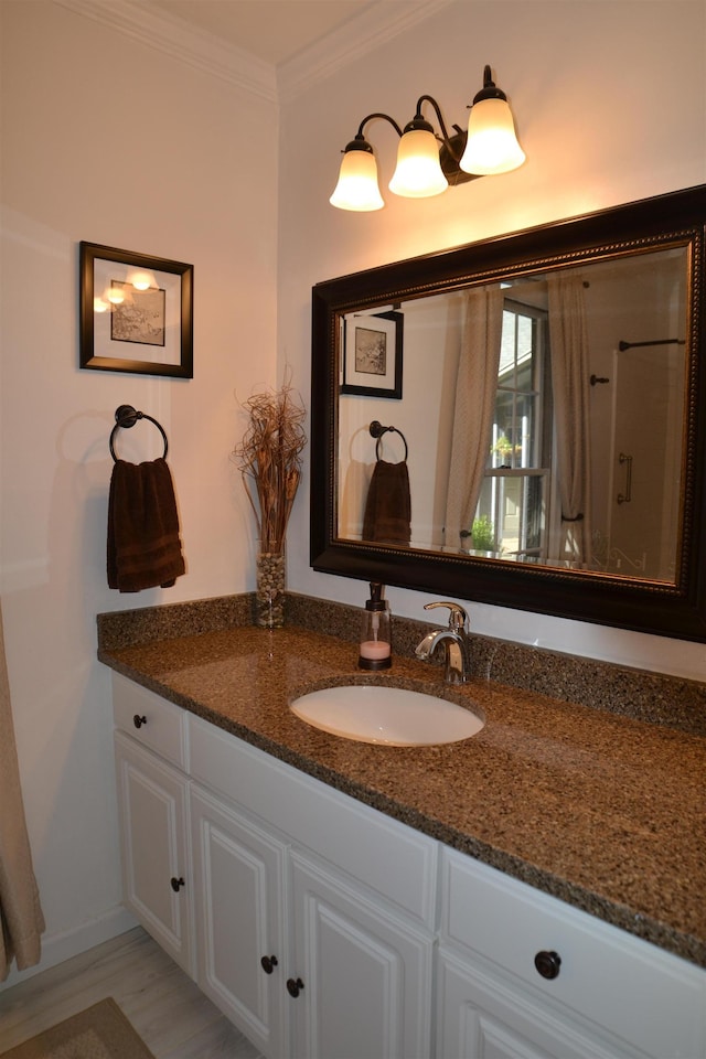 bathroom with hardwood / wood-style flooring, ornamental molding, and vanity