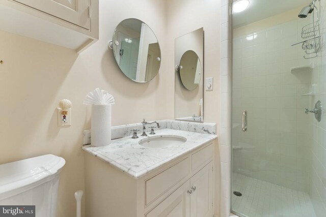 bathroom featuring vanity, an enclosed shower, and toilet