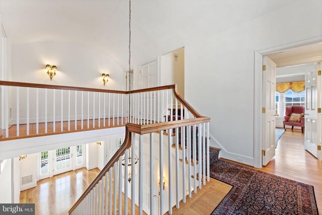 corridor featuring vaulted ceiling and light hardwood / wood-style floors