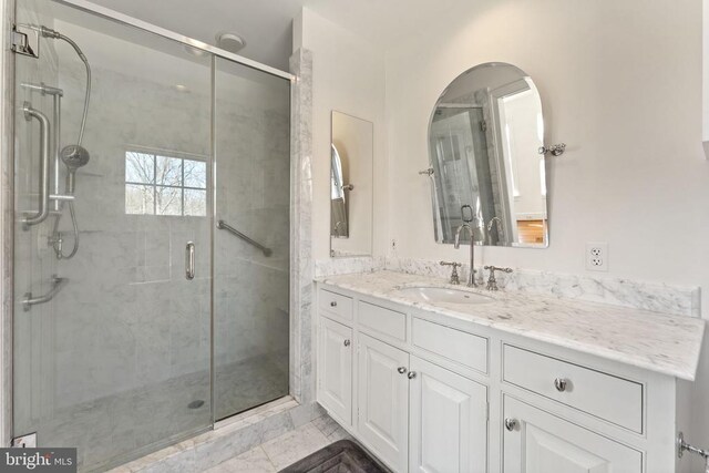 bathroom featuring vanity and a shower with door