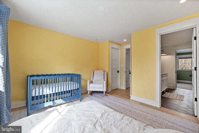 bedroom with baseboards, wood finished floors, and recessed lighting