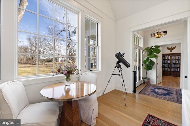 dining space featuring lofted ceiling, baseboards, and wood finished floors