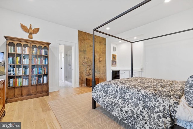 bedroom featuring beverage cooler, light wood finished floors, a dry bar, and recessed lighting