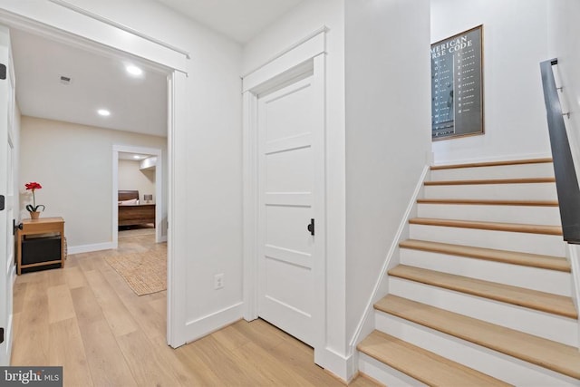 stairs with baseboards, wood finished floors, and recessed lighting