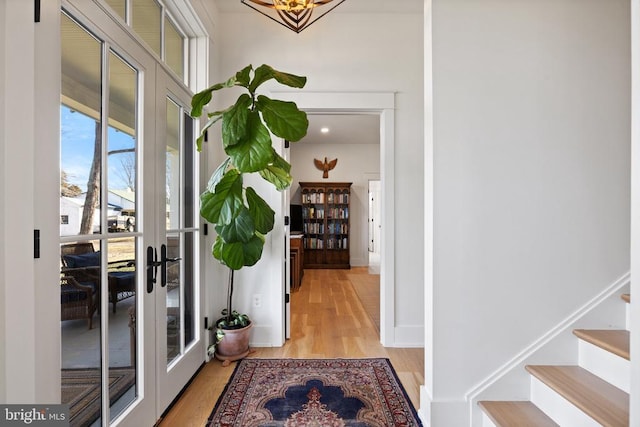 doorway featuring light wood-style floors, stairs, and french doors