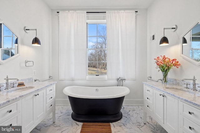 bathroom with a wealth of natural light, marble finish floor, and a sink