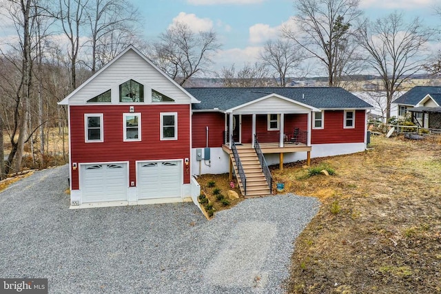 view of front facade featuring covered porch, a garage, roof with shingles, stairway, and gravel driveway