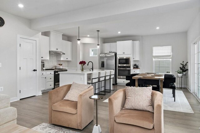 living area featuring recessed lighting, baseboards, and wood finished floors