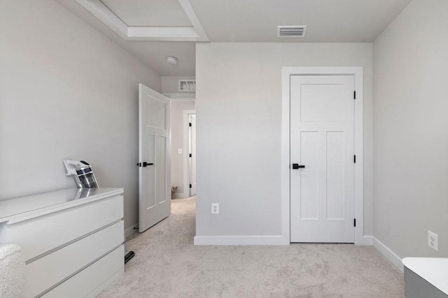 unfurnished bedroom featuring baseboards, visible vents, and light colored carpet