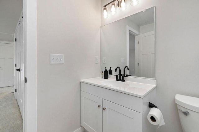 half bathroom with vanity and toilet