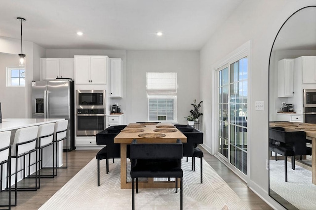 dining room with baseboards, wood finished floors, and recessed lighting