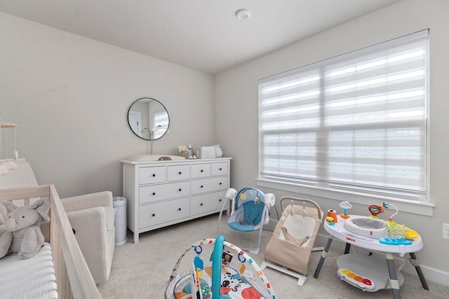 bedroom with light colored carpet and baseboards