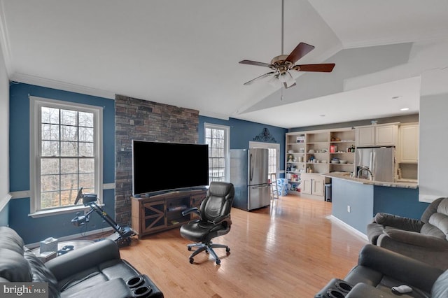 living room featuring vaulted ceiling, ceiling fan, and light wood-type flooring