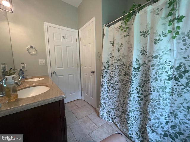 bathroom featuring tile patterned flooring, a sink, curtained shower, and double vanity